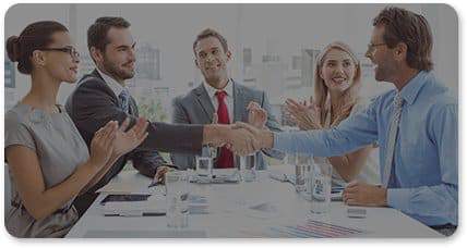A group of business executives and professionals concluding a meeting and shaking hands afterwards.